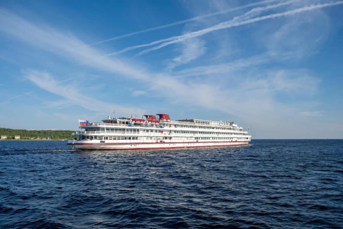 A large white ship sailing on calm waters, offering a premium Nile River Cruise experience for travelers