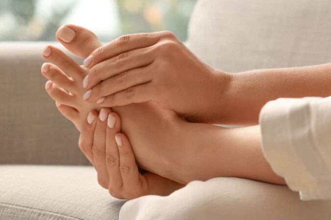 A close-up view showing self-massage techniques applied to a relaxed foot at home.